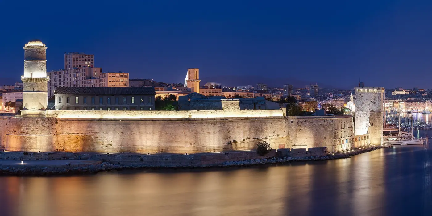 Le fort Saint-Jean et l'entrée du Vieux-Port de Marseille illuminés à la nuit tombée